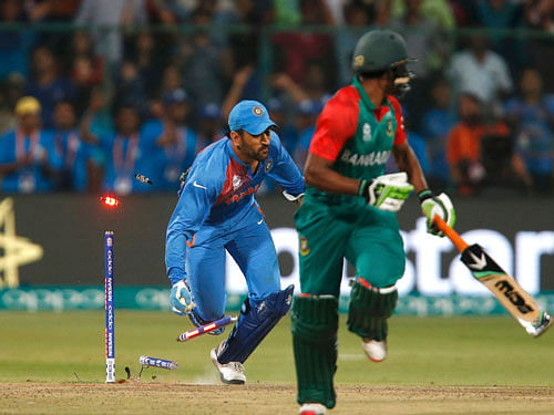 India's captain and wicketkeeper Mahendra Singh Dhoni (L) runs out Bangladesh's Mustafizur Rahman. REUTERS
