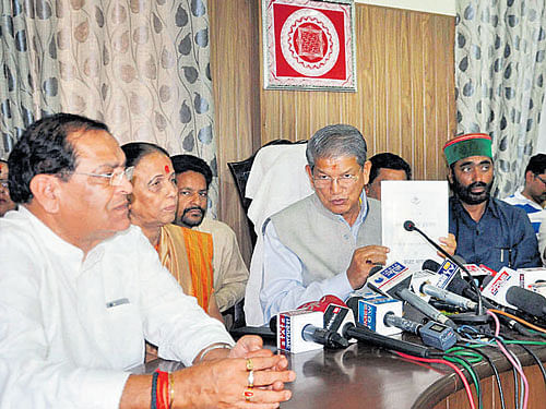 Former Uttarakhand chief minister Harish Rawat shows a copy of his government's budget to mediapersons in Dehradun on Tuesday. PTI