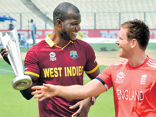 whose cup?: West Indian captain Darren Sammy (left) and his English counterpart Eoin Morgan enjoy a light moment on the eve of the final in Kolkata. PTI