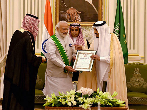 Prime Minister Narendra Modi being ordained the highest civilian award of Saudi Arabia, The Order of Abdullah, by King of Saudi Arabia Salman bin Abdulaziz Al Saud at his palace in Riyadh on Sunday. PTI Photo