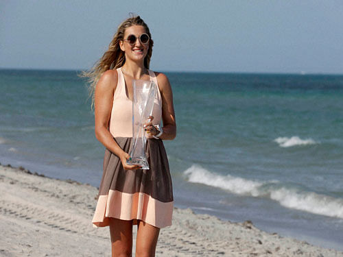 Victoria Azarenka, of Belarus, poses for a photograph on the beach with her trophy after defeating Svetlana Kuznetsova 6-3, 6-2, in the women's singles final match at the Miami Open tennis tournament, Saturday. AP/PTI