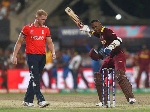 West Indies Marlon Samuels (R) celebrates past England's Ben Stokes after winning the final. REUTERS