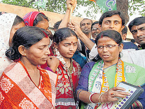 getting ready: TMC candidate Nilabati Saha demonstrates the working of an EVM to  villagers during a campaign in Birbhum, West Bengal, on Tuesday. PTI