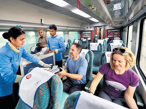 A hostess serves passengers aboard the newly launched 'Gatimaan Express', India's first semi-high speed train, in New Delhi on Tuesday. PTI