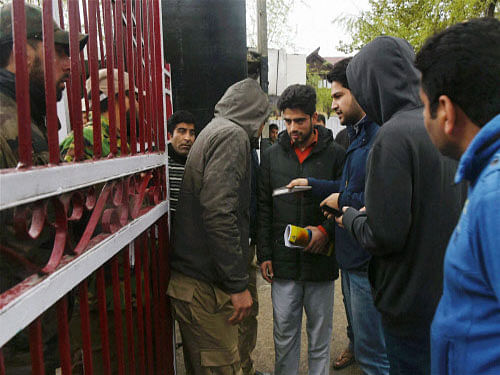 A police officer checks identity cards of students at National Institute of Technology (NIT) following tension between the local and non-local students of the institute, in Srinagar on Wednesday. PTI Photo