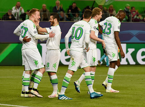 Team effort: Vfl Wolfsburg players celebrate after scoring their second goal against Real Madrid on Wednesday. Reuters