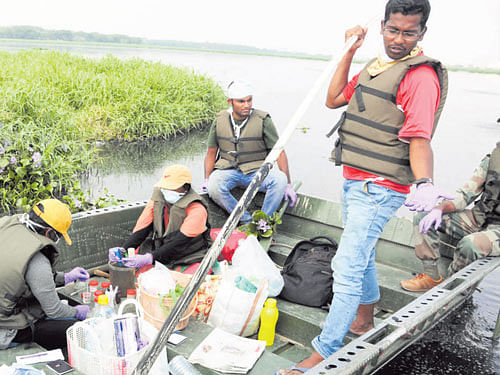 Volunteers collect water samples in Bellandur lake as part of the bathymetric survey on Tuesday. DH PHOTO