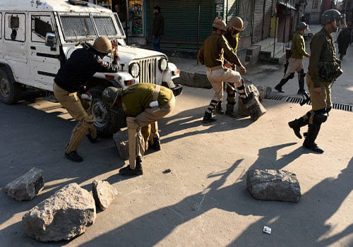 Police removes the barricades put up by angry protesters during clashes which erupted after the killing of two youth allegdely in Army firing fowllowing the molestation bid by a Jawan at Handwara in Kupwara district of north Kashmir,at Downtown Srinagar on Tuesday. PTI Photo