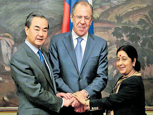 (L-C) Chinese Foreign Minister Wang Yi, Russian Foreign Minister Sergey Lavrov and Indian Foreign Minister Sushma Swaraj shake hands after a meet in Moscow, on Monday. PTI