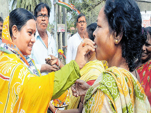 Trinamool Congress candidate Firdouse Begham offers sweet to a woman at a rally in South 24 Parganas on Monday. PTI