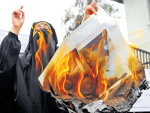 RISING DISSENT: A woman activist burns portraits of Prime Minister Narendra Modi during a protest in Srinagar on Tuesday against the recent deaths of five people after troops fired on protesters incensed by the 'molestation' of a girl by a soldier in Kashmir.