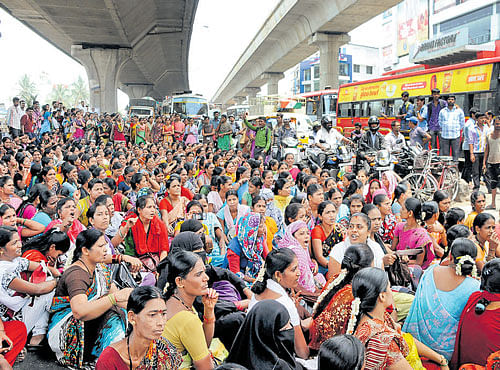 Garments workers stage a dharna at T Dasarahalli in Bengaluru on Tuesday. DH PHOTO