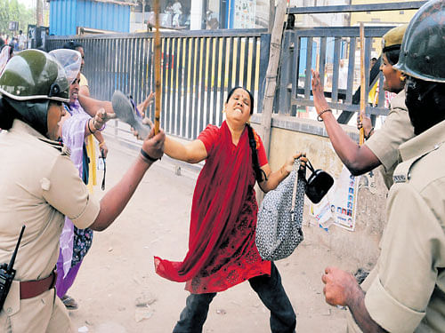 A woman attacks policewomen during the protest by garment workers at T&#8200;Dasarahalli on Tumakuru Road on Tuesday. DH Photo.