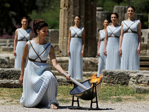 A dancer dressed as priestesses lights the Olympic flame with a parabolic mirror during the ceremonial lighting of the Olympic flame in Ancient Olympia, Greece, Thursday, April 21, 2016. The flame will be transported by torch relay to the Brazilian city of Rio de Janeiro, which will host the 2016 Olympic Games. AP/PTI