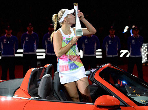 Tournament winner Angelique Kerber of Germany poses with her trophy in her reward, a Porsche Boxster 718, after winning her final match against Laura Siegemund of Germany at the WTA tennis tournament in Stuttgart, Germany, Sunday, April 24, 2016. AP/PTI