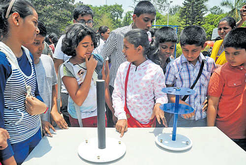 Students curiously watch the scientific equipment which explains the 'No Shadow'  phenomenon at Jawaharlal Nehru Planetarium in Bengaluru on Monday. DH Photo