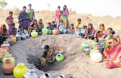 Women await their turn to extract water from a pit on the river bed near Nandihalli of  Shahpur taluk in Yadgir district on Tuesday. DH&#8200;Photo by krishnakumar P S
