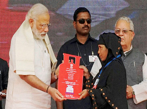 Prime Minister Narendra Modi presents cooking gas connection to a woman of Below Poverty Line (BPL) family during a launch of 'Pradhan Mantri Ujjwala Yojana' in Ballia on Sunday. PTI