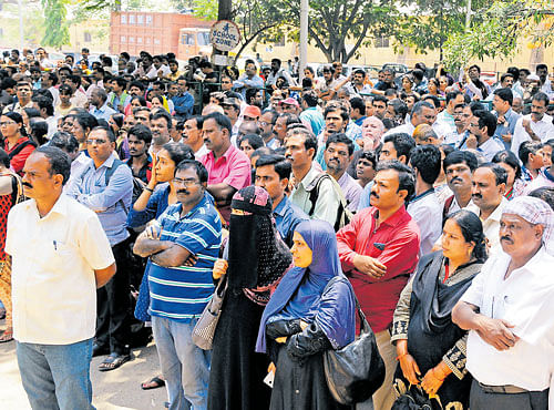 Parents wait for their children outside the Army Public School in Bengaluru as they take the NEET. dh Photo