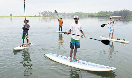 in harmony Enthusiasts engaged in stand-up paddle in River Shambhavi.