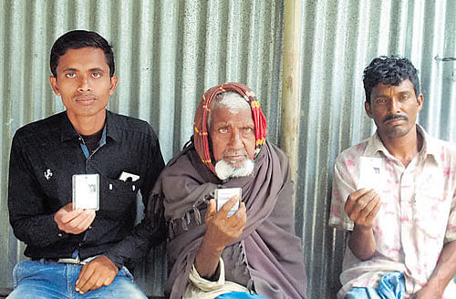 MY VOTE MY RIGHT: MdAsgar Ali, with his grandson Jainul Abedin on his right and youngest son Billal Hossain on his left, showtheir EPICs. Three generations will go to the polling booth together on May 5. DH PHOTO