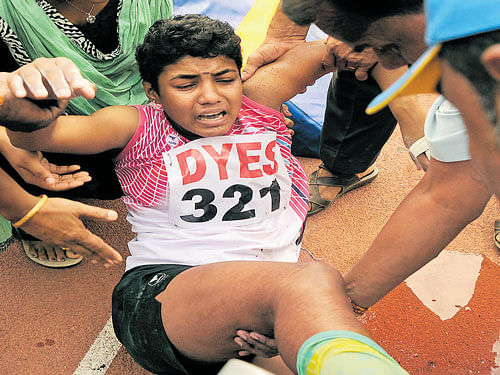 bruised Kerala's Shani Shaji screams in agony after injuring her right ankle during the pole vault event. dh photo
