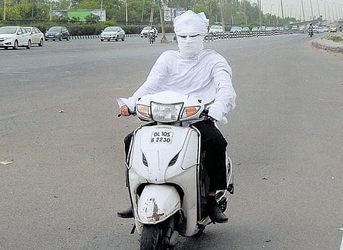 PROTECTING ONESELF: A man covers himself during a dust storm in Gurgaon on Wednesday.