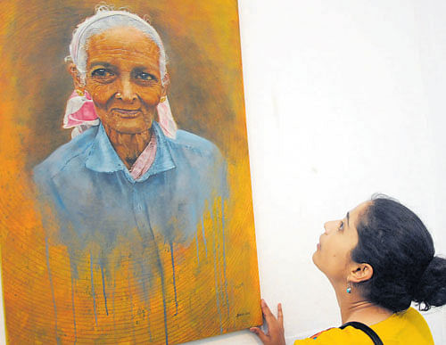 Artist Sara Joseph displays her paintings at the 'Art Marathon' at  Venkatappa Art Gallery on Monday. DH Photos