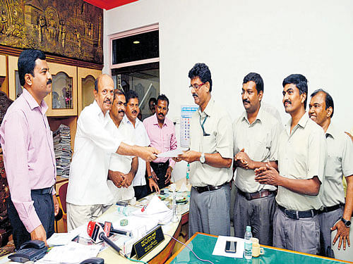 Mangaluru Mayor Harinath and MCC Commissioner Dr H N Gopalakrishna hand over the agreement letter to the MCF representatives on sale of city compost at the Mayor's chamber in Mangaluru on Tuesday. DH photo
