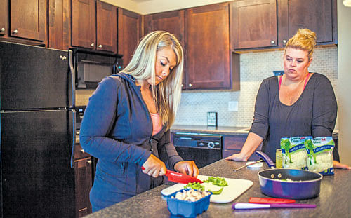 no respite: Amanda Arlauskas, a former contestant on 'The Biggest Loser,' cooks at her home. Before the show, Arlauskas was 250 pounds, at the finale she was down to 163 pounds; now she weighs 176 pounds and burns 591.1 fewer calories per day than would be expected for a woman of her size. nyt