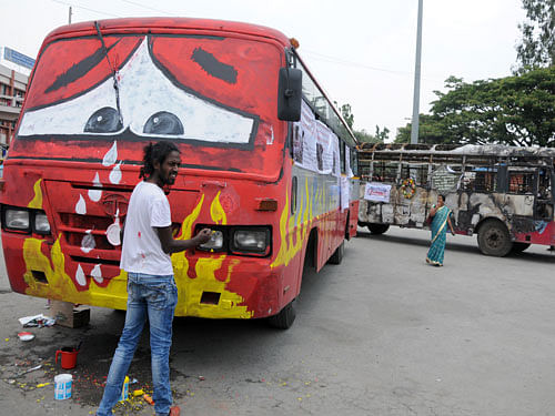 Artist Badal Nanjundaswamy turns a KSRTC bus into his canvas as part of a public awareness campaign 'It's My Bus' at Majestic in Bengaluru on Tuesday. DH PHOTO