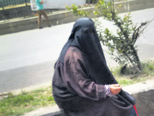 A woman in burqa and a child (right) beg on Moulana Azad Road in Srinagar. Zulfikar Majid