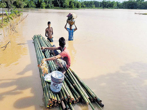 Off to safer zone: People shift to safe places from a flooded locality in Dharmanagar, North Tripura, on Wednesday. PTI