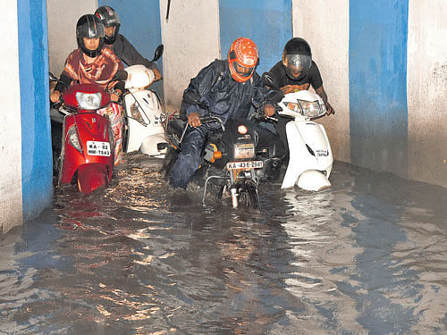 Motorists wade through a waterlogged underpass in Bellari Road near the Bangalore Golf Club on Wednesday. dh hoto/S K Dinesh