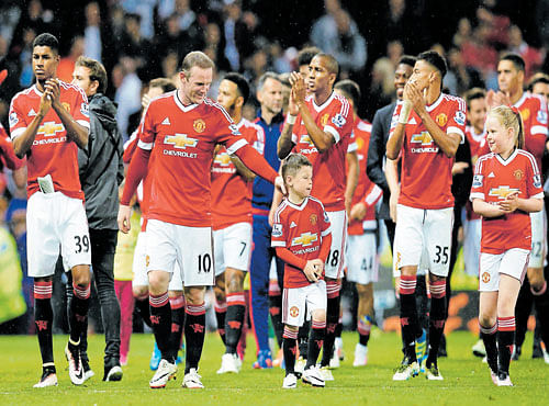 RED BRIGADE:Manchester United players acknowledge the crowd after their final league game at Old Trafford. REUTERS