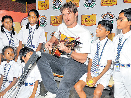 Royal Challengers Bangalore all-rounder Shane Watson strums a guitar during a charity event in the city on Thursday. DH PHOTO