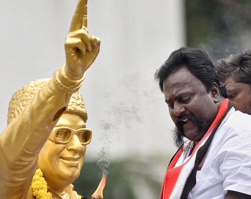 An AIADMK supporter celebrates near the MGR statue at the party headquarters in Chennai on Thursday. PTI