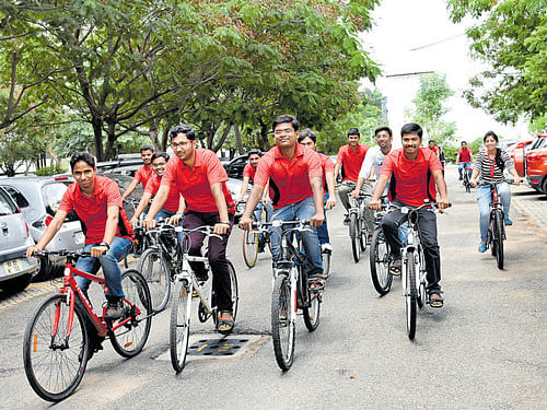 The employees of Texas Instruments cycle their way to work to mark International Bike to Work Day on Friday. DH photo