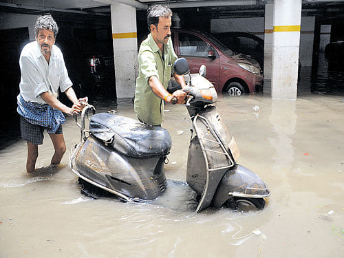 deluge Two-wheelers and cars at a parking lot in a residential enclave at JP Nagar were  submerged following the flooding caused by Thursday night showers. DH PHOTO