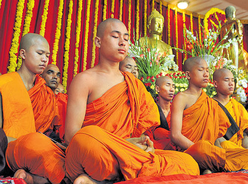 Buddhist monks take part in a mass prayer during 'Buddha Jayanti Utsava -2016' at Mahabodhi Society on Saturday. DH PHOTO