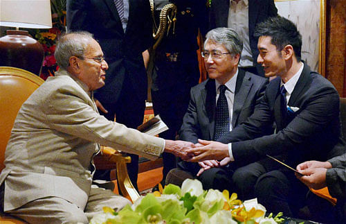 President Pranab Mukherjee shares greetings with famous Chinese film actor Huang Xiaoming in Beijing, China on Wednesday. PTI Photo