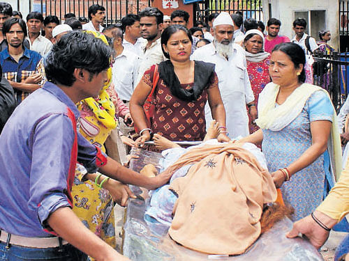 The family members take the body of a patient who died due to delay in treatment at LNJP Hospital in New Delhi on  Thursday. DH photo