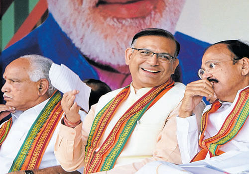 Union Minister of State for Finance Jayant Sinha has a word with Union Urban Development Minister Venkaiah Naidu at the BJP's 'Vikas Parva' rally in Bengaluru on Friday. BJP state president B S Yeddyurappa is seen. dh photo