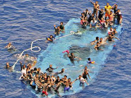 People ask for help after their boat overturned off the Libyan coast Thursday, May 26, 2016. A migrant boat sank off Libya's coast Thursday with about 100 passengers on board. Officials said 88 people had been rescued and that some 20 bodies were spotted in the sea. AP/ PTI