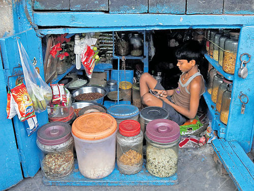 soured dreams: A boy uses a mobile phone as he sits inside his father's shop in Kolkata. The rage that developed against the Congress propelled Modi forward. It was not a mandate for gentle reform, but for profound change from the ground up. reuters