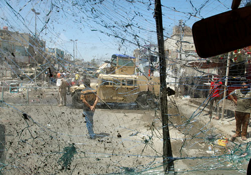 An Iraqi security vehicle is pictured through a shattered windshield of a vehicle damaged at the site of a bomb attack in Baghdad's northern Shaab Shi'ite district, Iraq, May 30, 2016. REUTERS