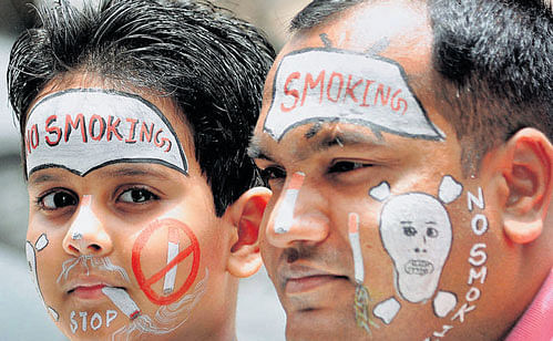 People have their faces painted with no-smoking messages ahead of World No Tobacco Day in Bikaner on Monday. PTI
