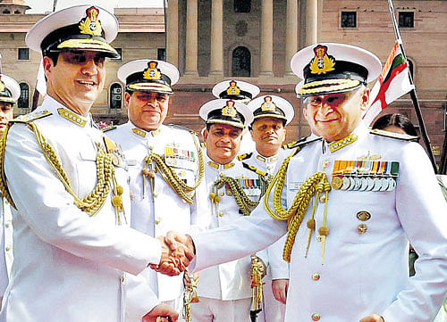 New Navy chief Admiral Sunil Lanba (Right) and outgoing chief Robin K Dhowan shake hands before inspecting a Guard of Honour at a ceremony in South Block, New Delhi on  Tuesday. PTI