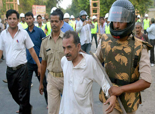 Police personnel caught an encroacher during the clash in Mathura on Thursday. PTI Photo