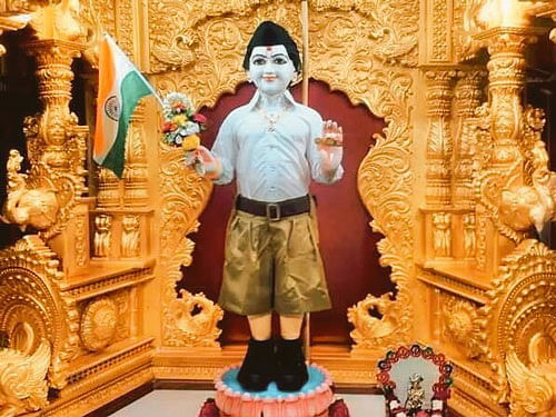 The issue came to light after a picture, in which Lord Swaminarayan can be seen donning the Sangh outfit, white shirt tucked into a baggy khaki shorts with black cap and black shoes on went viral on social media platforms last evening. The idol is also seen holding the national flag in one hand. Image courtesy: Twitter